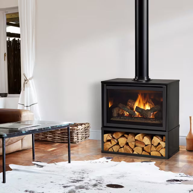Majestic Trilliant. A black wood-burning stove with a visible fire and logs, set in a styled living room with a cowhide rug, wooden floor, and furniture.